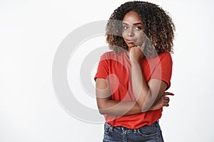 Indoor shot of creative and confident good-looking young african-american woman in red t-shirt leaning head on fist and