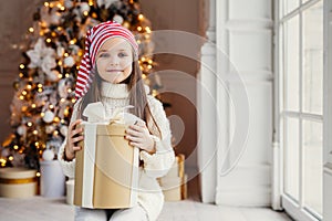 Indoor shot of pleasant looking small kid with blue charming eye