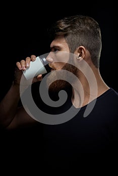 Brutal bearded man drinking coffee to go photo