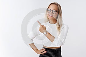 Indoor shot of successful good-looking energized creative female entrepreneur with fair hair in glasses and watch