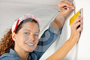 indoor shot young woman using leveling tool at home