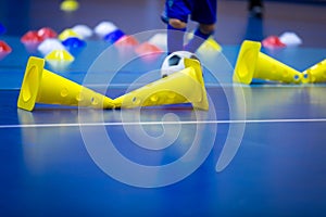 Indoor soccer player on training during the winter. Futsal training field with blue cones