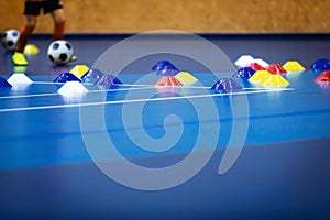 Indoor soccer player on training during the winter. Futsal training field with blue cones