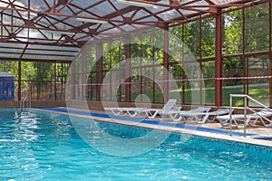 Indoor swimming pool in a modern hotel with Sunbeds