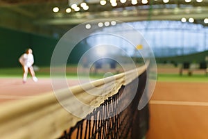 Indoor tennis court playing athlete girl