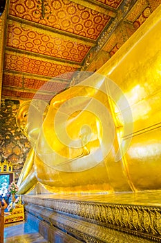 Indoor view of reclining Buddha gold statue. Wat Pho, Bangkok, Thailand