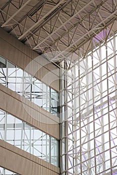 Indoor white metal rafters reflected on glass windows
