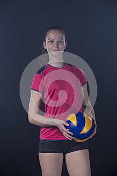 Indoor young volleyball woman player isolated on dark background