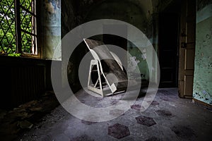 Indoors shot of an abandoned hospital corridor with an old Trendelenburg table in the corridor