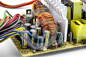 Induction coil, toroidal coil on a ring with visible copper helix and capacitors, mounted on a printed circuit board in a computer