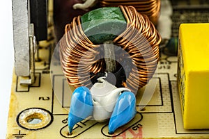 An inductor, toroidal coil on a ring with visible copper scroll, wound on a magnetic coil.