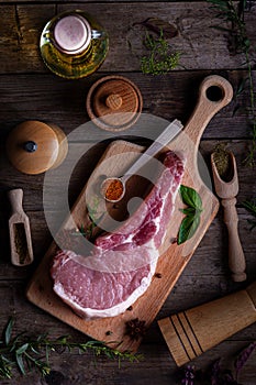 Indulge in the rustic charm of a raw piece of pork loin on a wooden board