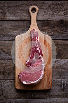 Indulge in the rustic charm of a raw piece of pork loin on a wooden board