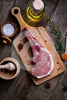 Indulge in the rustic charm of a raw piece of pork loin on a wooden board