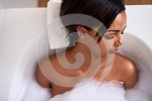 Indulging in a blissfull bath. Shot of an attractive young woman relaxing in a bubble bath.