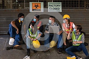 Industrail background of diverse factory workers, labors and engineer with wearing medical mask sitting together in front of