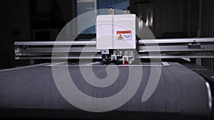 An industrial advertising plotter close-up cuts a template on the cardboard packaging for products. shallow depth of
