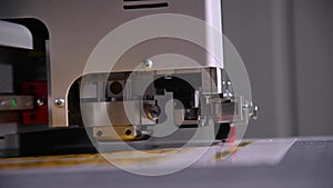 An industrial advertising plotter close-up cuts a template on the cardboard packaging for products. shallow depth of