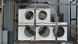 Industrial air conditioner units HVAC near industrial building with working fans.