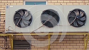 Industrial air conditioning sustem on the wall outdoors. Rotating fans conditioner of an industrial building