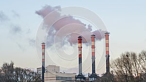 Industrial air pollution. Winter landscape with factory and trees. The concept of environmental pollution.