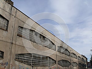 Industrial archeology buildings in the city of Busto Arsizio. Facade of an old factory with glass block windows