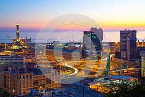 Industrial area near the port with Lanterna and commercial skyscrapers at sunset, Genoa, Italy.