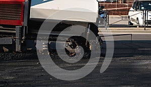 Industrial asphalt paver machine laying fresh asphalt on road construction site on the street. A Paver finisher placing