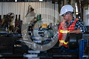 Industrial background of caucasian mechanic engineer with lathe machine in metal work and machine part manufacturer workshop and photo