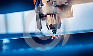Industrial background CNC laser machine cutting sheet metal with light spark. Concept modern steel technology, blue