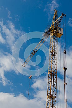 Industrial background with construction crane over blue cloudy sky