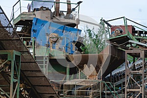 Industrial background - crusher rock stone crushing machine at open pit mining and processing plant for crushed stone, sand and