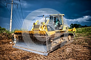 Industrial backhoe, bulldozer moving earh and sand in sandpit
