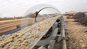 Industrial belt conveyor moving raw materials.