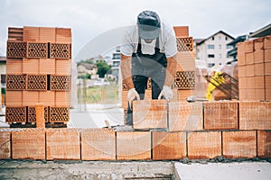 industrial bricklayer installing bricks on construction building site