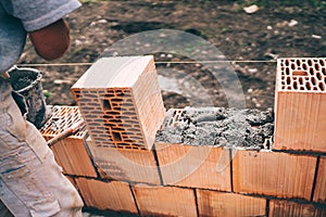 Industrial bricklayer installing bricks on construction site