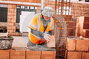 industrial bricklayer installing bricks on construction site