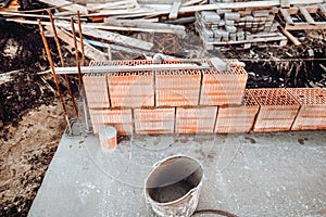 Industrial bricklayer installing bricks on construction site. Details of house building