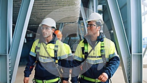 Industrial builder group in protective helmet uniform walking refinery chemical plant control