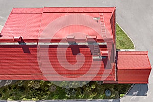 Industrial building from above. red metal roof with installed pipes of ventilation systems