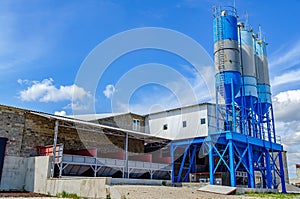 Industrial building with big blue tanks for cement, sand, water. Paving plant. Panoramic photo