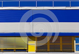 Industrial building with blue and yellow metal siding trim. Abstract background
