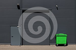 Industrial building with rolling gate for loading dock and large waste container