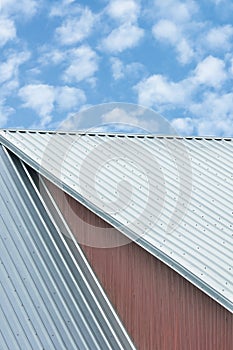 Industrial building roof sheets, grey steel rooftop pattern, bright summer clouds cloudscape, blue sky, rifled roofing panels