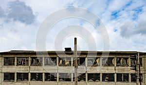 An industrial building with sealed windows against a blue sky.