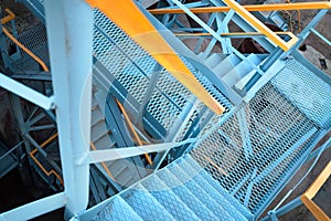 Industrial building structure fragment featuring metal staircases and pillars. Abstract image on the subject of modern