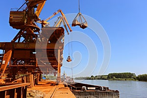 Industrial cargo port with operating cranes on the Danube river