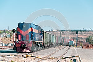 Industrial cargo train with blue red loco at railway