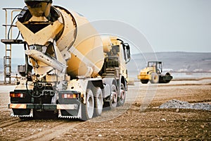 Industrial Cement truck on highway construction site. Heavy duty machinery at work on construction site