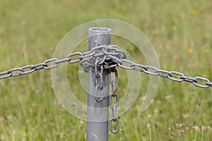 Industrial chain attached to a galvanised fence post